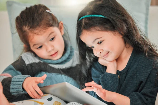 Two Young Sisters Using Digital Tablet Together Sofa Home — Foto Stock