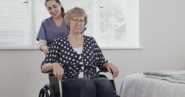 Imágenes Video Una Enfermera Empujando Paciente Anciano Silla Ruedas — Vídeos de Stock
