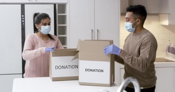 Video Footage Couple Wearing Masks Gloves While Packing Boxes Charity — Stockvideo