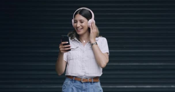 Şık Bir Kadın Tasasız Görünüyor Bluetooth Kulaklıkla Müzik Dinliyor Şehirde — Stok video