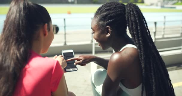 Female Athletes Laughing While Using Phone Browsing Online Together Exercise — Stockvideo