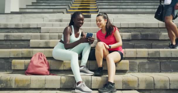 Two Female Athletes Using Phone Talking Workout Sports Stadium Fit — Stockvideo