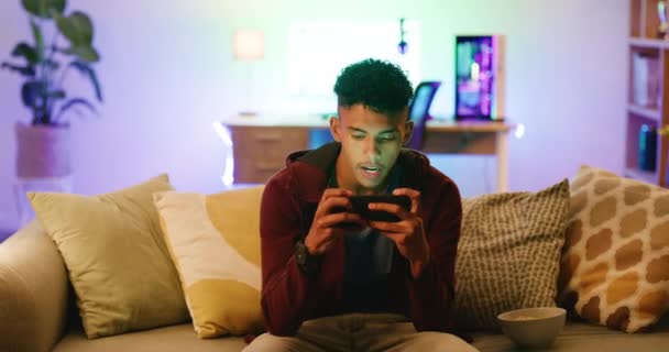 Joven Enojado Con Videojuego Teléfono Mientras Está Sentado Sofá Casa — Vídeos de Stock