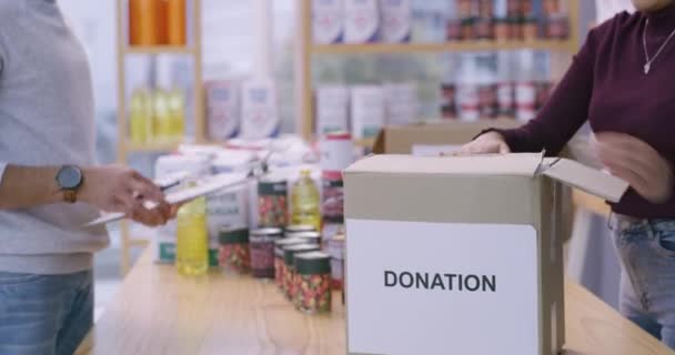 Video Footage Couple Checking Food Items Donated Placing Them Box — Stockvideo