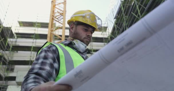 Βίντεο Ένα Νεαρό Άνδρα Εξετάζει Σχέδια Κτιρίων Εργοτάξιο — Αρχείο Βίντεο