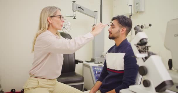 Ophthalmologist Giving Male Patient Eye Test Exam Room Female Optician — Video