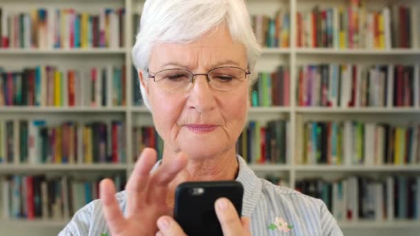 Happy Pensioner Browsing Ebook Reader Application Senior Librarian Phone Smiling — Stockvideo