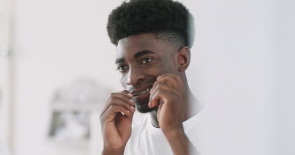 Видеозапись Красивого Молодого Человека Чистящего Зубы Зубной Нитью Перед Зеркалом — стоковое видео