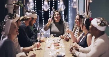 4k video footage of a group of young friends toasting with wine at a Christmas dinner party.