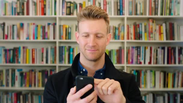 Homem Moderno Usando Seu Telefone Uma Livraria Biblioteca Estudante Elegante — Vídeo de Stock
