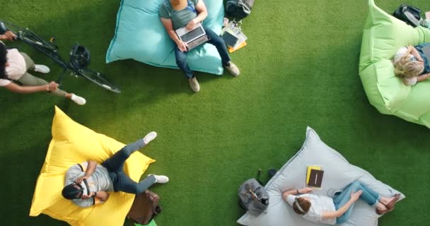 Group Diverse Students Using Technology Sitting Beanbags Library Bright Informal — 图库视频影像