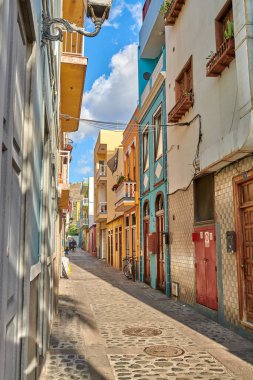 Colorful historic buildings in vibrant city of Santa Cruz de La Palma with cobblestone alleyway on a sunny day. Bright residential houses in a popular village of a travel and tourism destination.