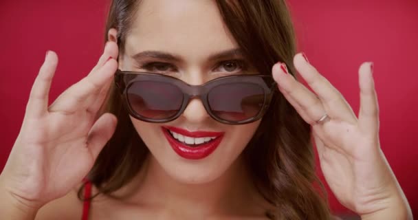 Videomateriaalia Kaunis Nuori Nainen Kurkistaa Hänen Aurinkolasit Silmää Vastaan Punainen — kuvapankkivideo