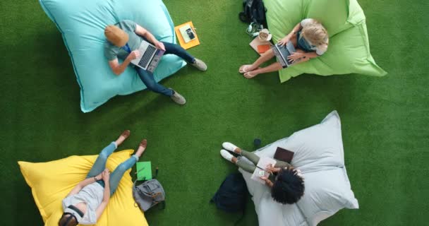 Студенты Использующие Современные Технологии Сидящие Бобах Библиотеке Сверху Яркое Неформальное — стоковое видео
