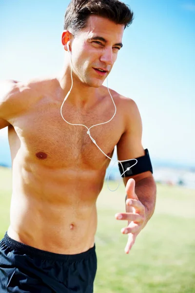 Portrait of a handsome young guy running against the sky.