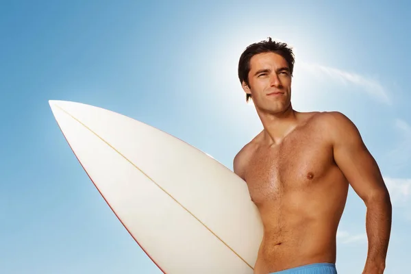 Przystojny Mężczyzna Surfer Stojący Przed Błękitnym Niebem — Zdjęcie stockowe