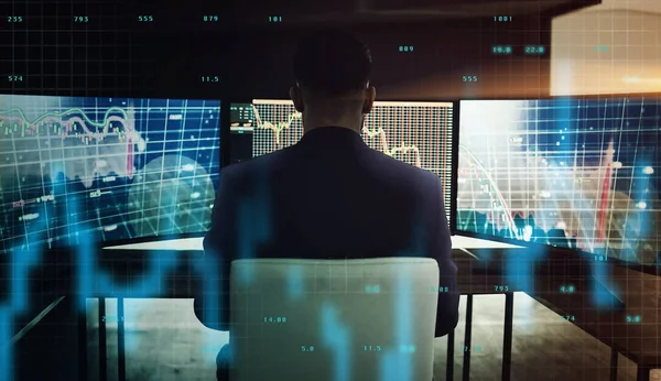 a businessman sitting in his office monitoring the stock market.