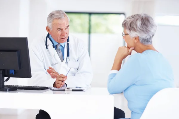 Confident Mature Doctor Discussing Medical Report Female Patient — Stock fotografie