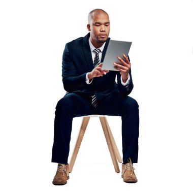 Genç ve yakışıklı bir iş adamının beyaz bir arkaplanda tablet kullanırken çekilmiş bir fotoğrafı..