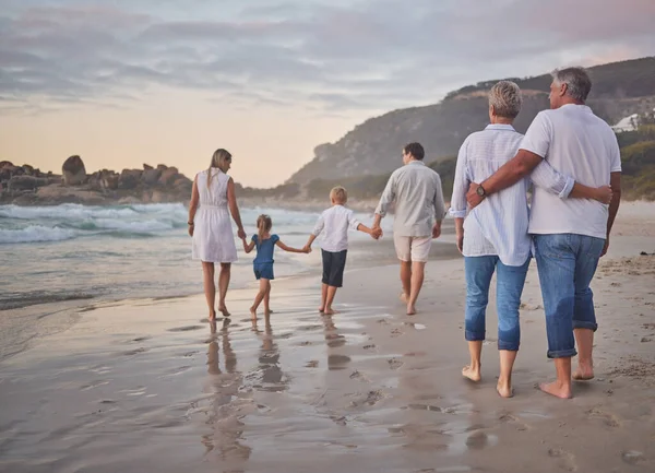 Rear View Multi Generation Family Holding Hands Walking Beach Together – stockfoto