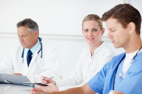 Portrait Young Doctor Sitting Boardroom Table Flanked Her Colleagues — Fotografia de Stock