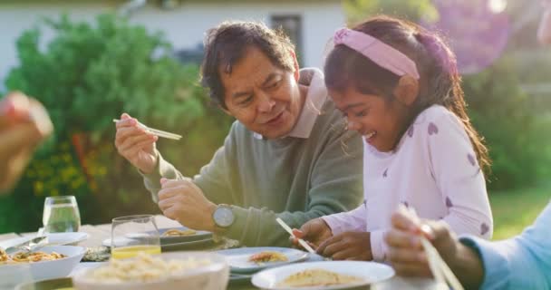 Avô Orgulhoso Assistindo Sua Neta Comer Enquanto Almoça Família Quintal — Vídeo de Stock