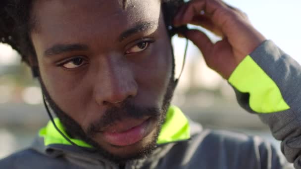 Homem Negro Desportivo Usando Fones Ouvido Preparando Para Uma Corrida — Vídeo de Stock