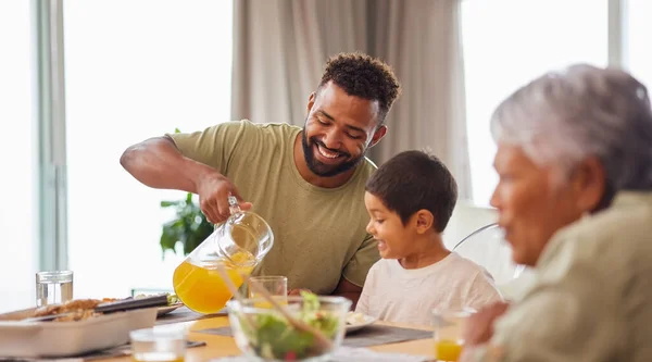 一位男女混血的男子和他的儿子在休息室吃午饭的时候 在餐桌边享用食物 西班牙裔父亲笑着和儿子一起在家里吃饭 — 图库照片