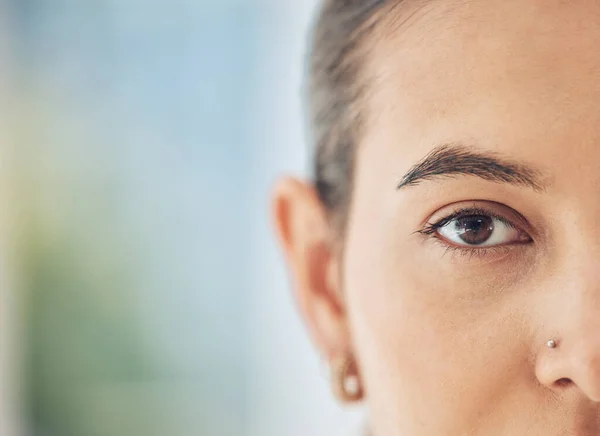 Closeup shot of a mixed race woman, half faced, with a nose piercing looking straight at the camera. Beautiful young multi ethnic female staring head on. Confident, proud and firm in her femininity.