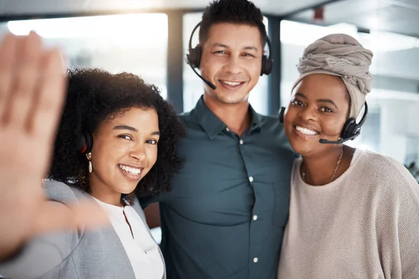 Portrait of a diverse group of happy smiling call centre telemarketing agents taking selfies together in an office. Confident and ambitious consultants determined to provide the best customer service