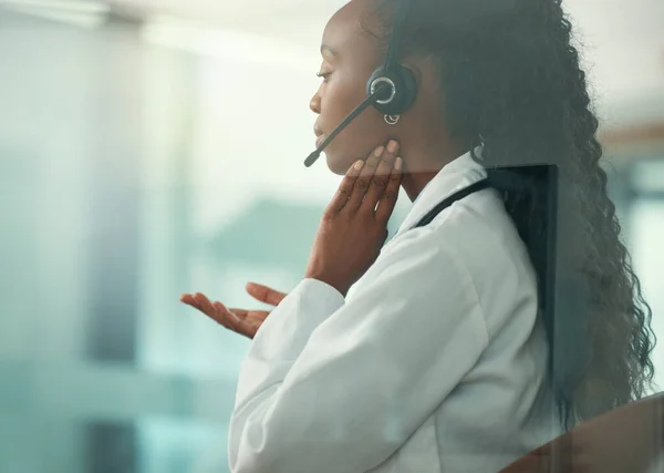 Medical call center rep with a sore throat.customer service agent touching her neck in pain. Medical doctor on a telehealth call with a patient. African American doctor working in a call center.