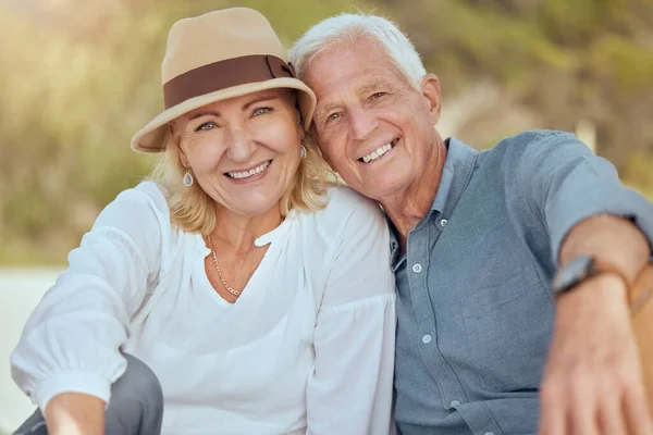 A happy mature caucasian couple enjoying fresh air on vacation at the beach. Smiling retired couple sitting and having a romantic picnic in a garden or backyard.