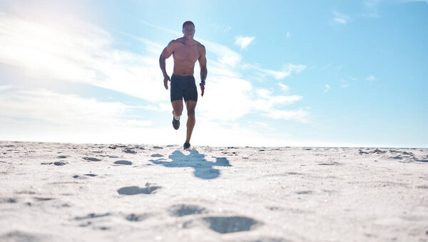 Подходит молодой чернокожий мужчина, бегающий и бегающий по песку на пляже утром для физических упражнений. Один сильный мужчина бодибилдер спортсмен с шесть пакет абс делать кардио тренировки, чтобы построить мышцы и выносливость.