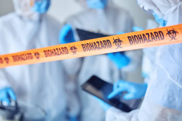 Closeup Biohazard Quarantine Tape Hands Scientist Using Digital Tablet Covid — Zdjęcie stockowe