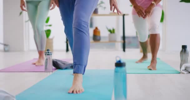 Olgun kadınlar, birlikte spor salonunda yoga yapıyorlar. Kadınlar yoga eğitmeniyle fitness sınıfında egzersiz yapıyor, daha iyi duruş, denge ve kardiyo için pozisyon alıyorlar..