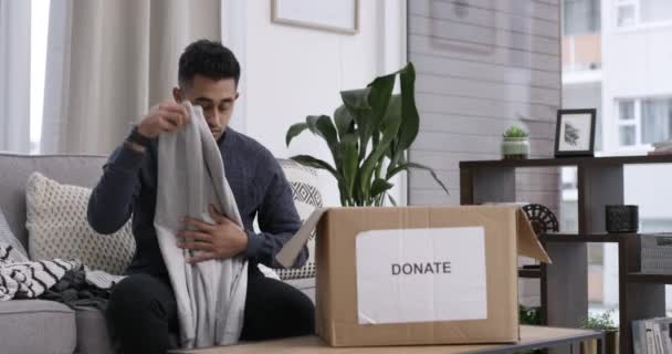 Video Footage Man Packing Clothes Donation Box While Sitting Home — Stockvideo