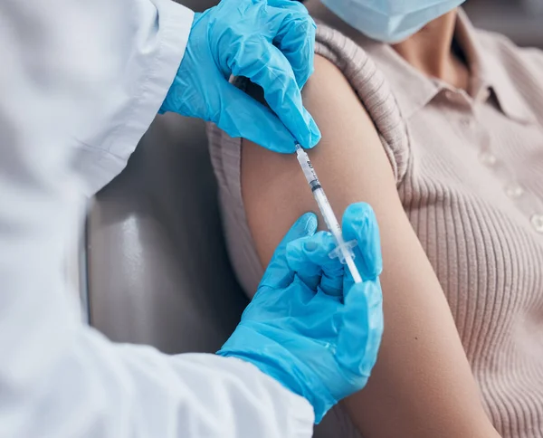 a woman receiving a vaccination shot from her doctor.