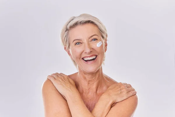 一个快乐成熟的高加索女人赤身裸体面对着紫色的彩色背景的肖像 在工作室的护肤过程中 老年妇女使用乳霜 润肤霜 防晒霜 — 图库照片