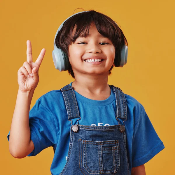 Uroczy Mały Azjatycki Chłopiec Słuchający Muzyki Słuchawkach Wykonujący Gest Pokoju — Zdjęcie stockowe