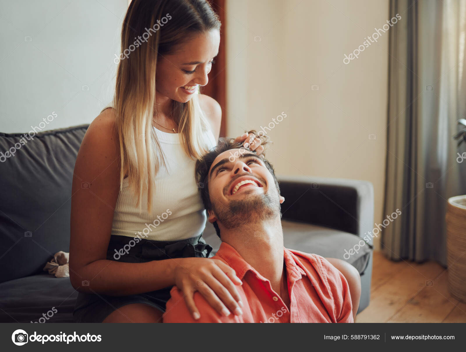Loving young caucasian couple sitting together at home spending time and  happy to be together. Happy