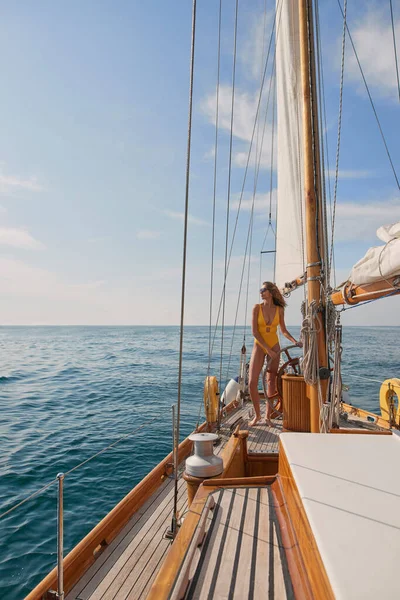 Content Young Woman Yellow Swimsuit Looking Ocean Steering Boat Cruise — Stock fotografie