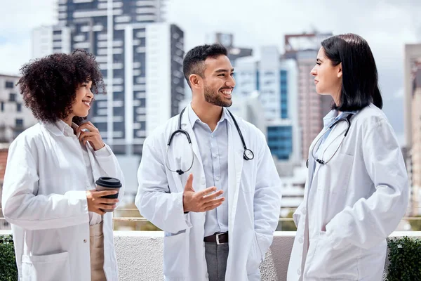 Dwie Lekarki Kolega Stojący Balkonie Przed Szpitalem Uśmiechający Się Rozmawiający — Zdjęcie stockowe