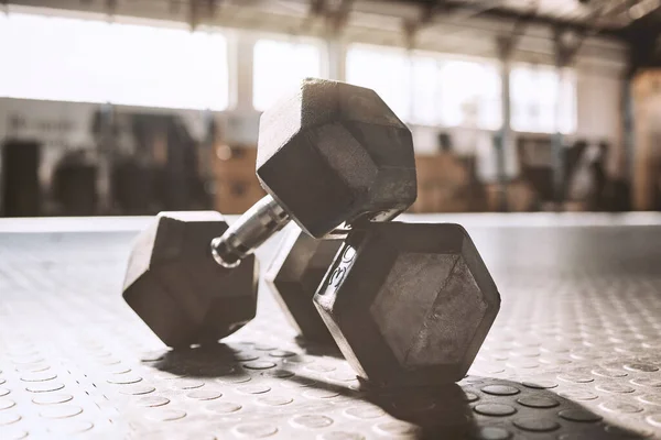 Neat dumbells on the gym floor.Workout equipment in empty gym. Bodybuilding equipment in the gym. Heavy weight make for better bodybuilding. Strength training requires dumbells