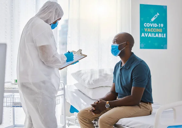 Patient talking to a doctor during a checkup. Specialist writing patients information on clipboard. Doctor reading patients covid report. Patient in a consult with a gp in a clinic.