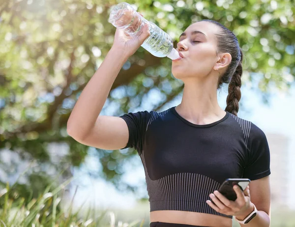 Young Female Athlete Taking Break Drinking Water Bottle Holding Smartphone — Stok fotoğraf
