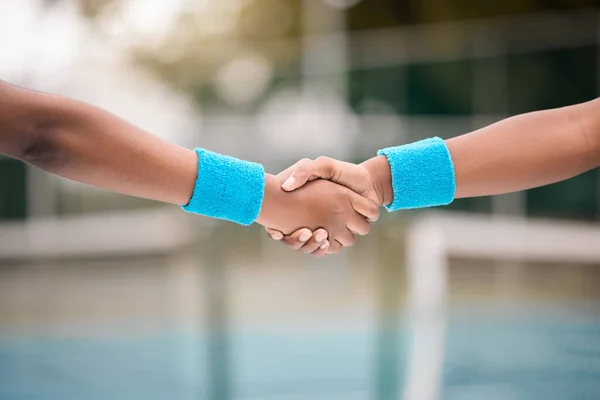 Two tennis players giving a handshake. African american professional tennis players greeting before a match. Tennis players collaborate before a practice match on the court.