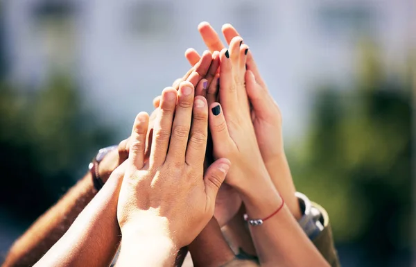 a group of people with their hands joined at a rallly.