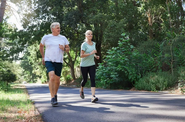 Mature Couple Running Together Outdoors — Stockfoto