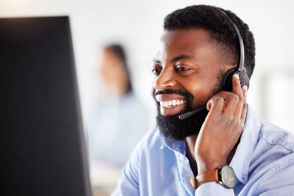 Ofiste Bilgisayarla Uğraşırken Kulaklıkla Konuşan Mutlu Bir Afro Amerikan Erkek — Stok fotoğraf