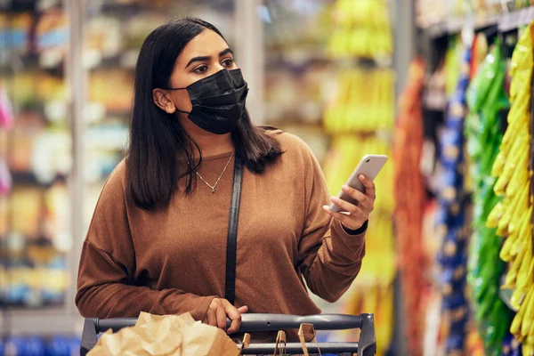 Woman Using Her Smartphone While Doing Her Grocery Shop — 图库照片